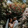 wedding couple in the Treseren gardens with pink flowers