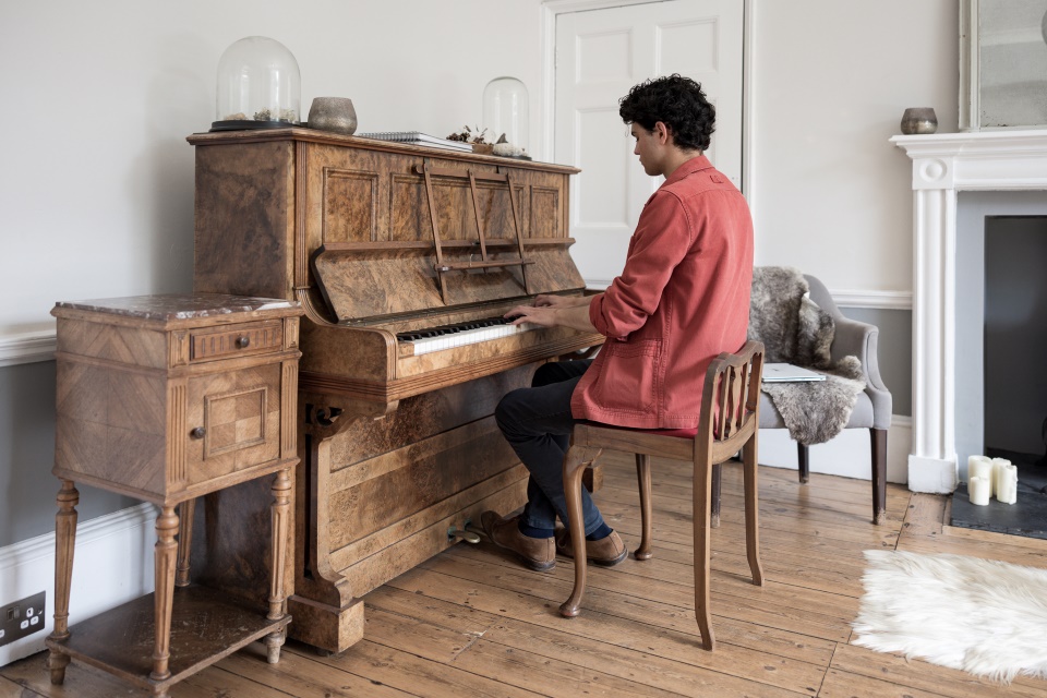 A pianist playing a wooden grand piano