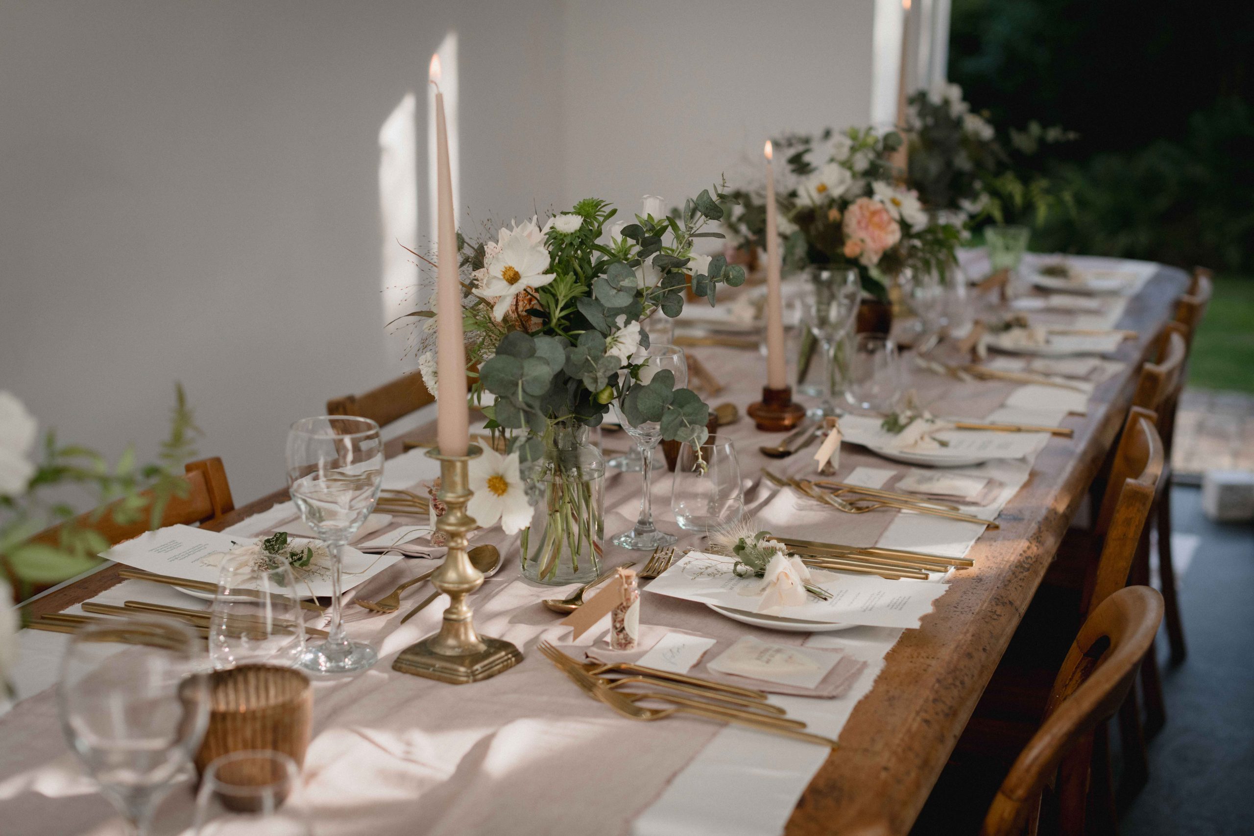 small wedding tablescape with gold candle holders and silk table runner