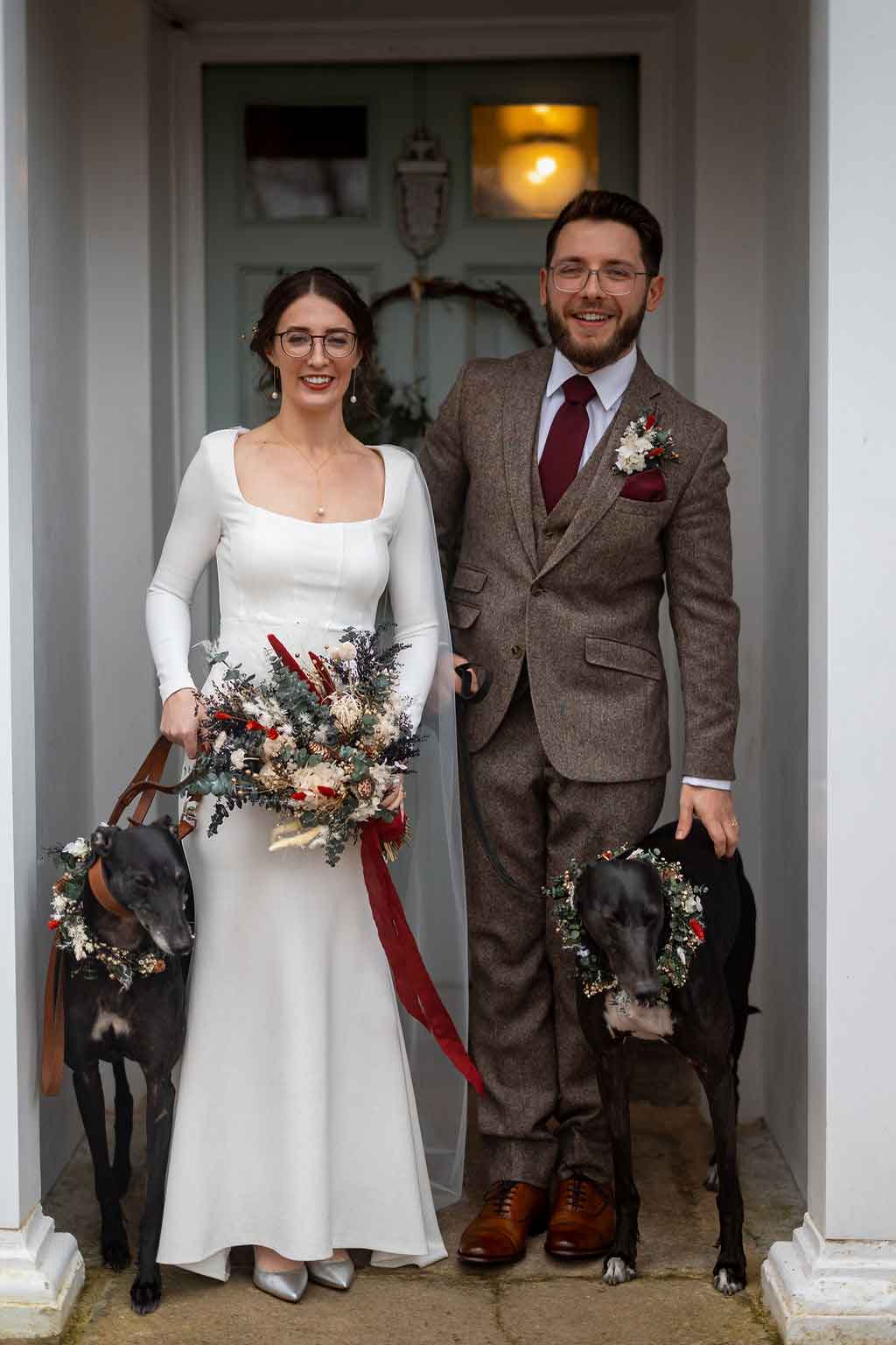 bride and groom with rescue greyhounds at dog friendly wedding venue in Cornwall
