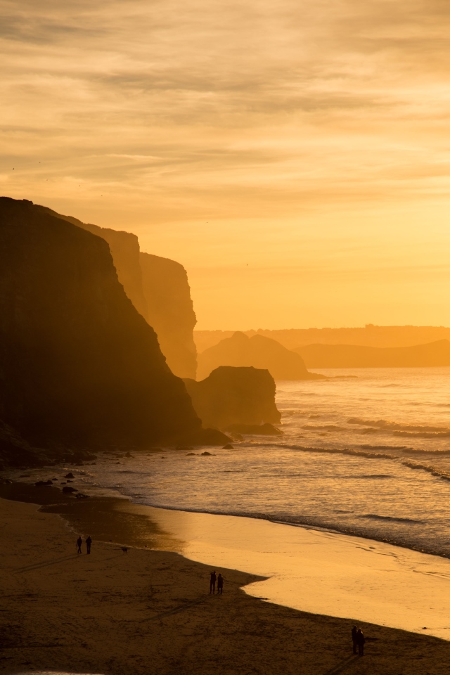 Hazy yellow light at sunset over cliffs and sea