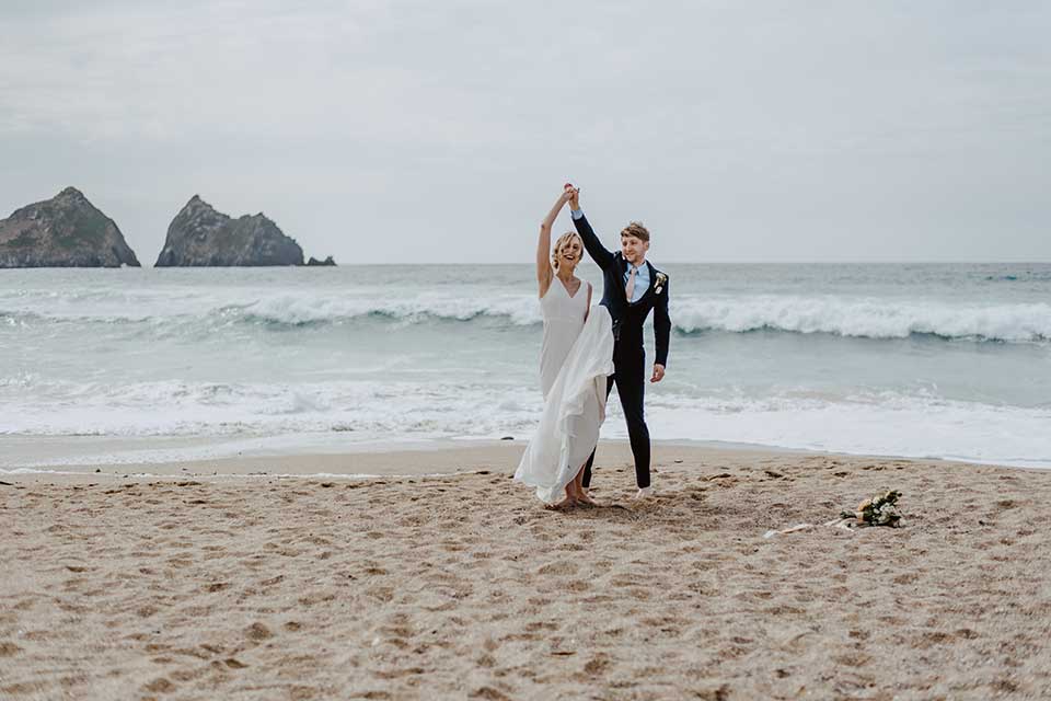 bride and groom dancing on the beach on their wedding day