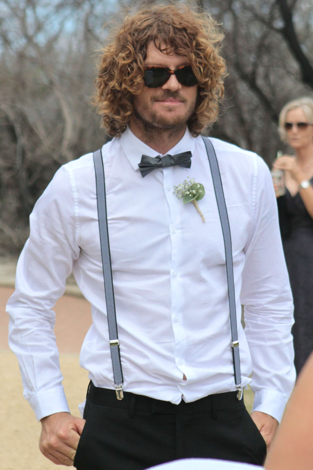 Best man in shirt braces and bow tie with sunglasses
