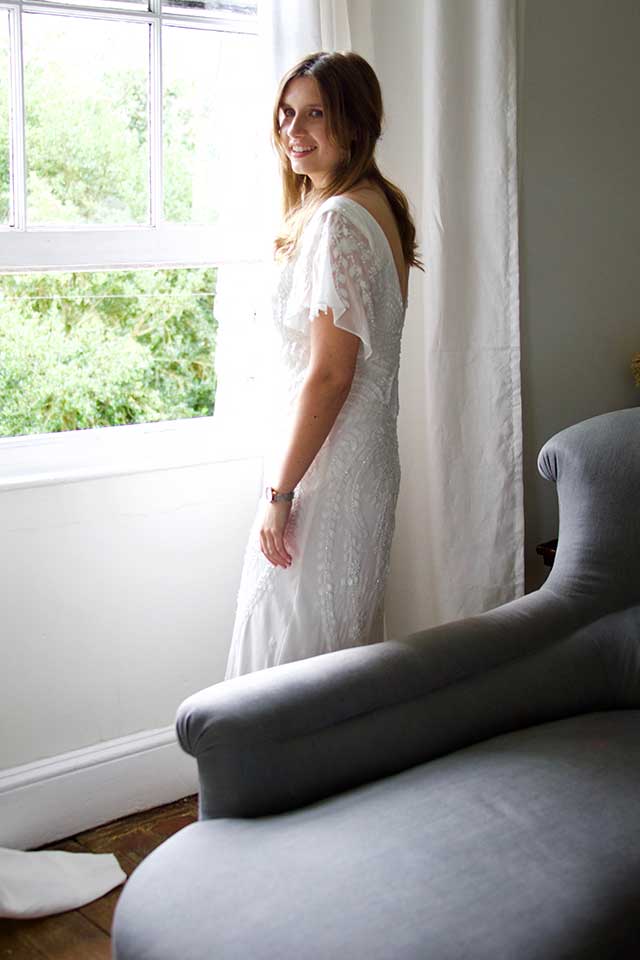 bride wearing wedding dress standing in window