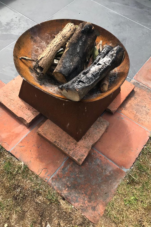 metal fire pit for toasting marshmallows on terracotta tiles