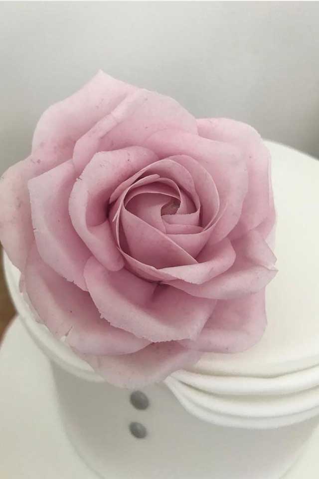close up of pink rose sugar flower handmade for small wedding cake