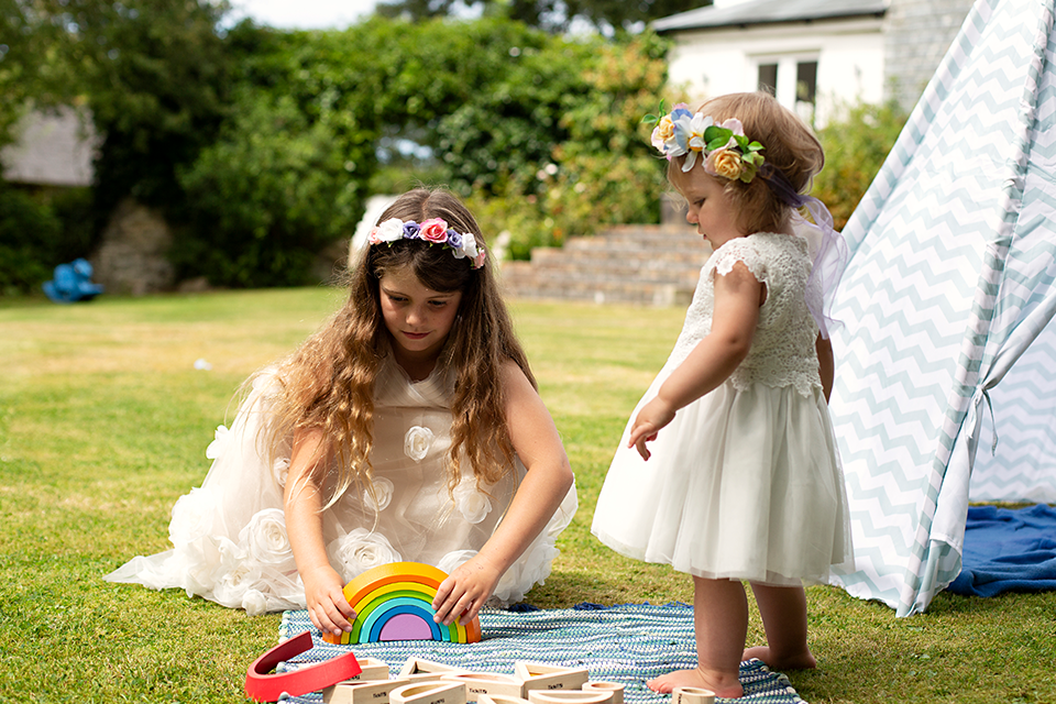 Two mini bridesmaids playing with wooden toys with wedding childcare