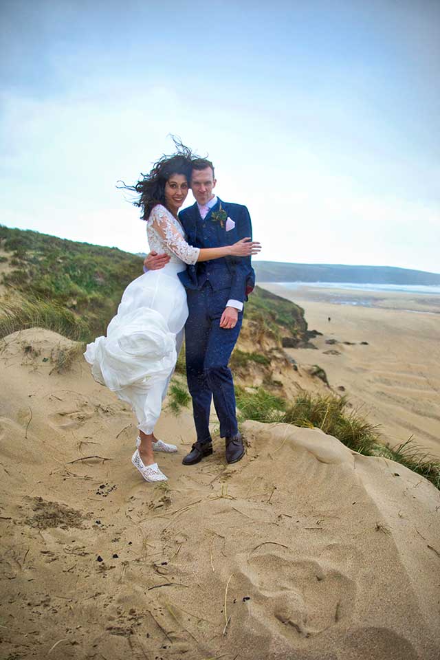 happy wedding couple on windy beach in autumn
